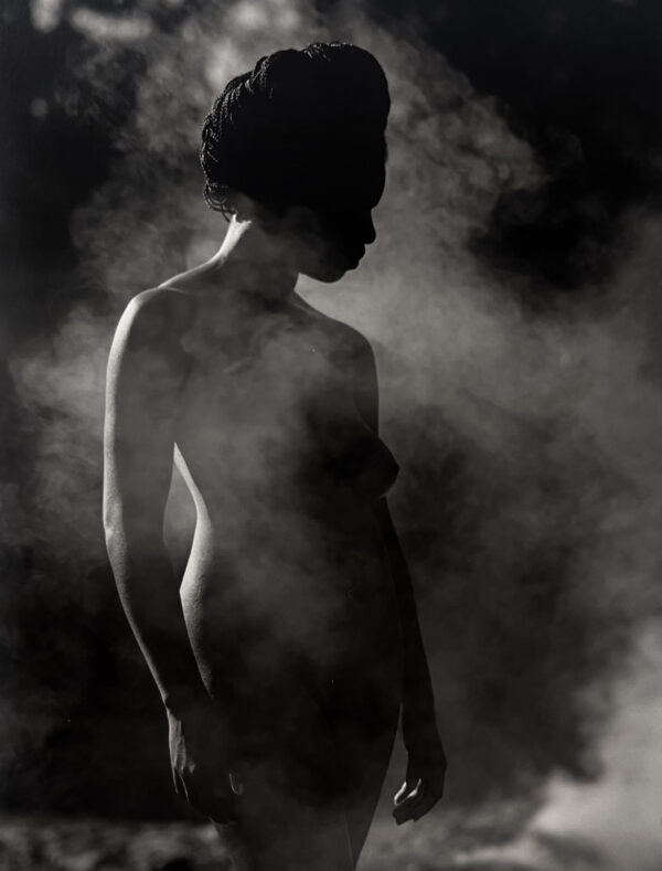 A woman standing in the middle of smoke.