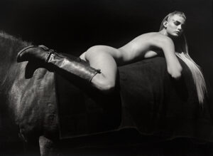 A woman in boots and jeans laying on the couch