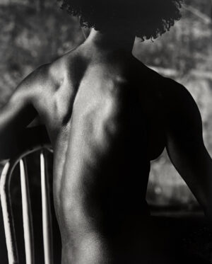 A man sitting in a chair with his back turned.