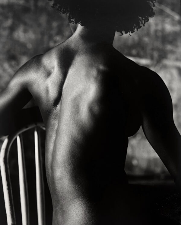 A man sitting in a chair with his back turned.