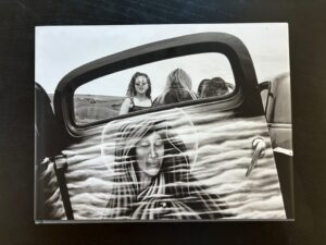 A woman in the back of an old car