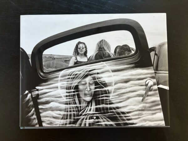 A woman in the back of an old car