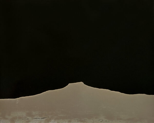 A black and white photo of a mountain with dark sky.