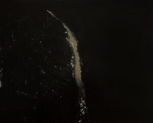 A white stream of water is seen in the dark.