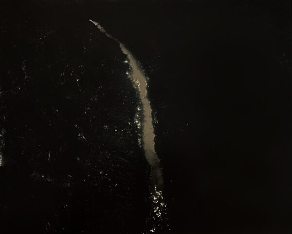 A white stream of water is seen in the dark.