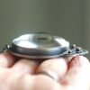 A person holding a silver object in their hand.