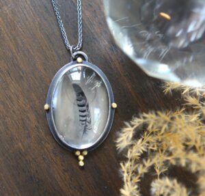 A necklace with a bird in it's center.
