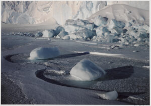 A group of ice bergs floating on top of the ocean.