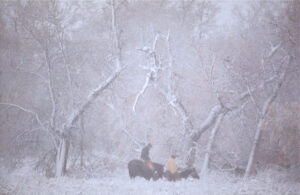 A group of people sitting on top of a horse in the snow.