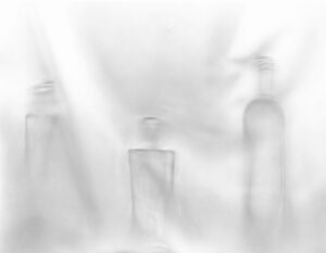 A blurry image of three bottles in the fog.