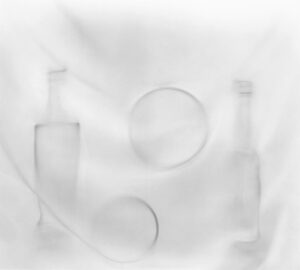 A white background with three bottles and two plates.
