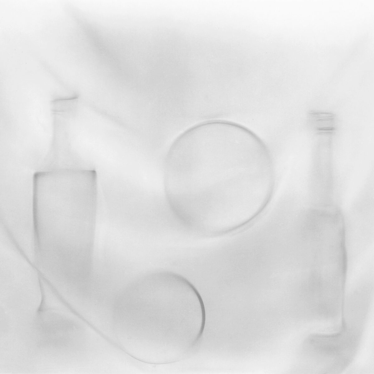 A white background with three empty bottles and two plates.