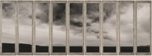 A series of windows with a cloudy sky in the background.