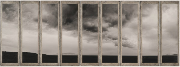 A series of windows with a cloudy sky in the background.