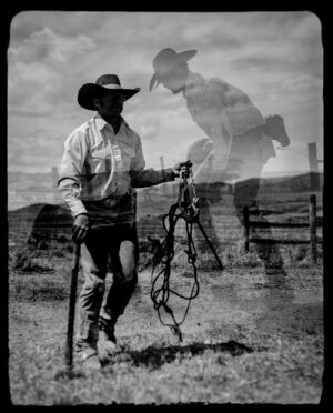 A man holding onto a horse in the middle of an open field.