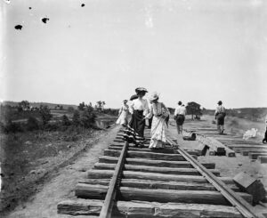 JENNIE ROSS COBB. Friends walk along the Ozark and Cherokee Central Railroad under construction, Tahlequah, Oklahoma, 1902.